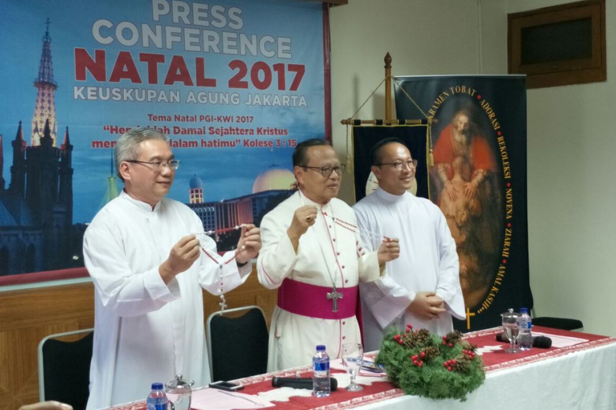 Uskup Agung Jakarta Mgr Ignatius Suharyo (tengah) memegang rosario merah putih di Gereja Katedral Jakarta, Senin (25/12/2017). 