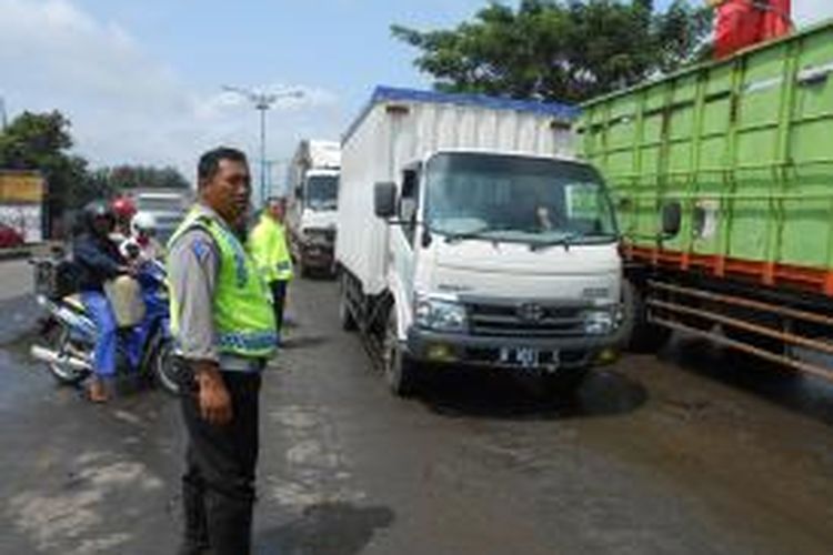 Polisi berusaha mengurai kemacetan di jalan raya Karanganyar, Demak, Kamis (30/1/2014)