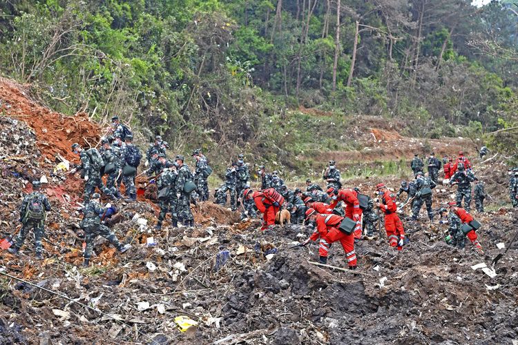 Petugas penyelamat melakukan operasi pencarian di lokasi kecelakaan pesawat di Kabupaten Tengxian di Daerah Otonomi Guangxi Zhuang, China Selatan, Selasa (22/3/2022). Petugas penyelamat menemukan barang pribadi dari 132 orang korban berupa kartu identitas, kartu ATM, dan dompet. Mereka terus melakukan pencarian menjelajahi lereng gunung terpencil untuk mencari puing-puing dan korban pesawat China Eastern.