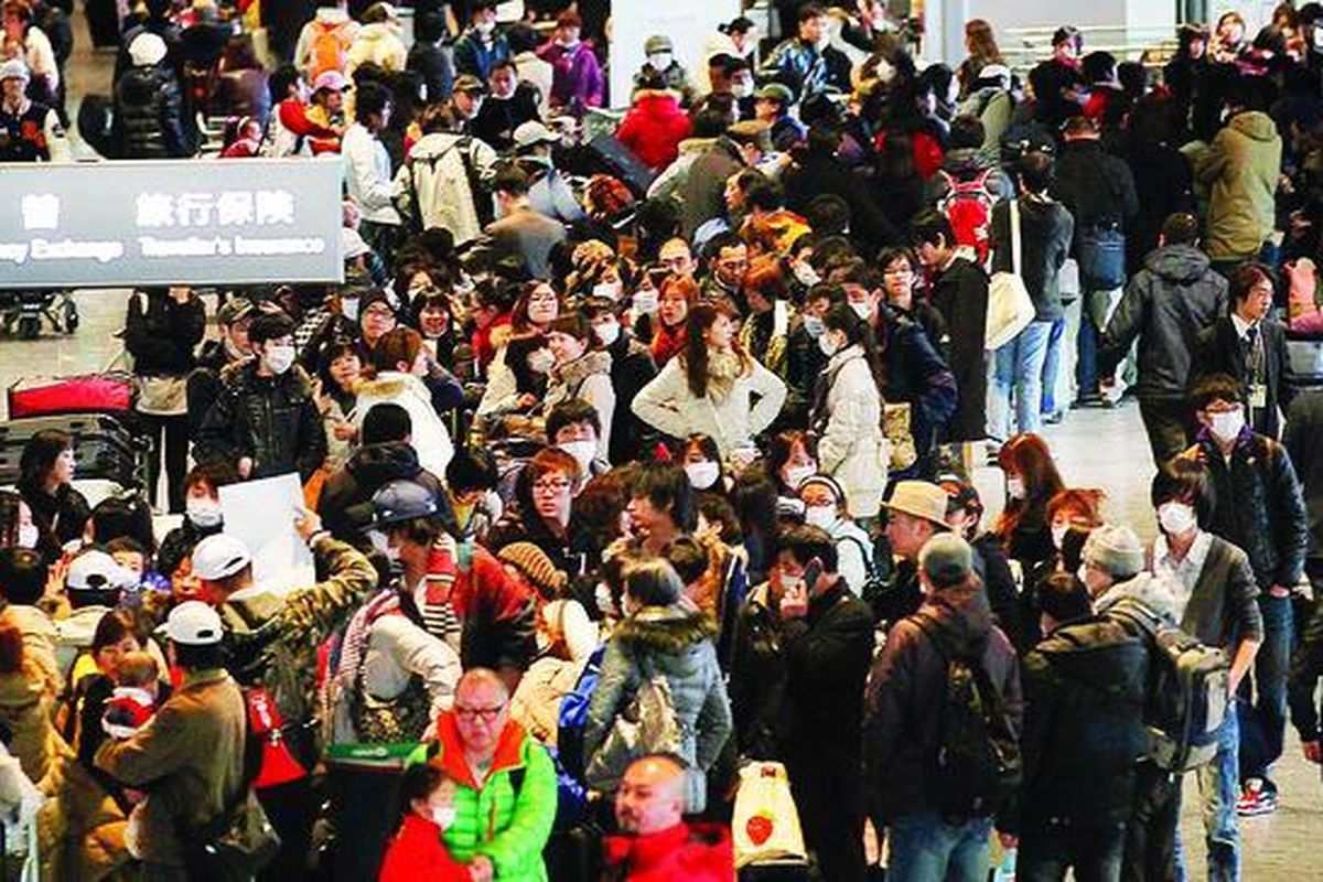 Warga dan pekerja mengantre untuk check-in pada penerbangan mereka di Bandar Udara Internasional Narita, Tokyo, Jepang, Kamis (17/3). Mereka khawatir reaktor nuklir di Prefektur Fukushima akan meledak karena pelindungnya meleleh.