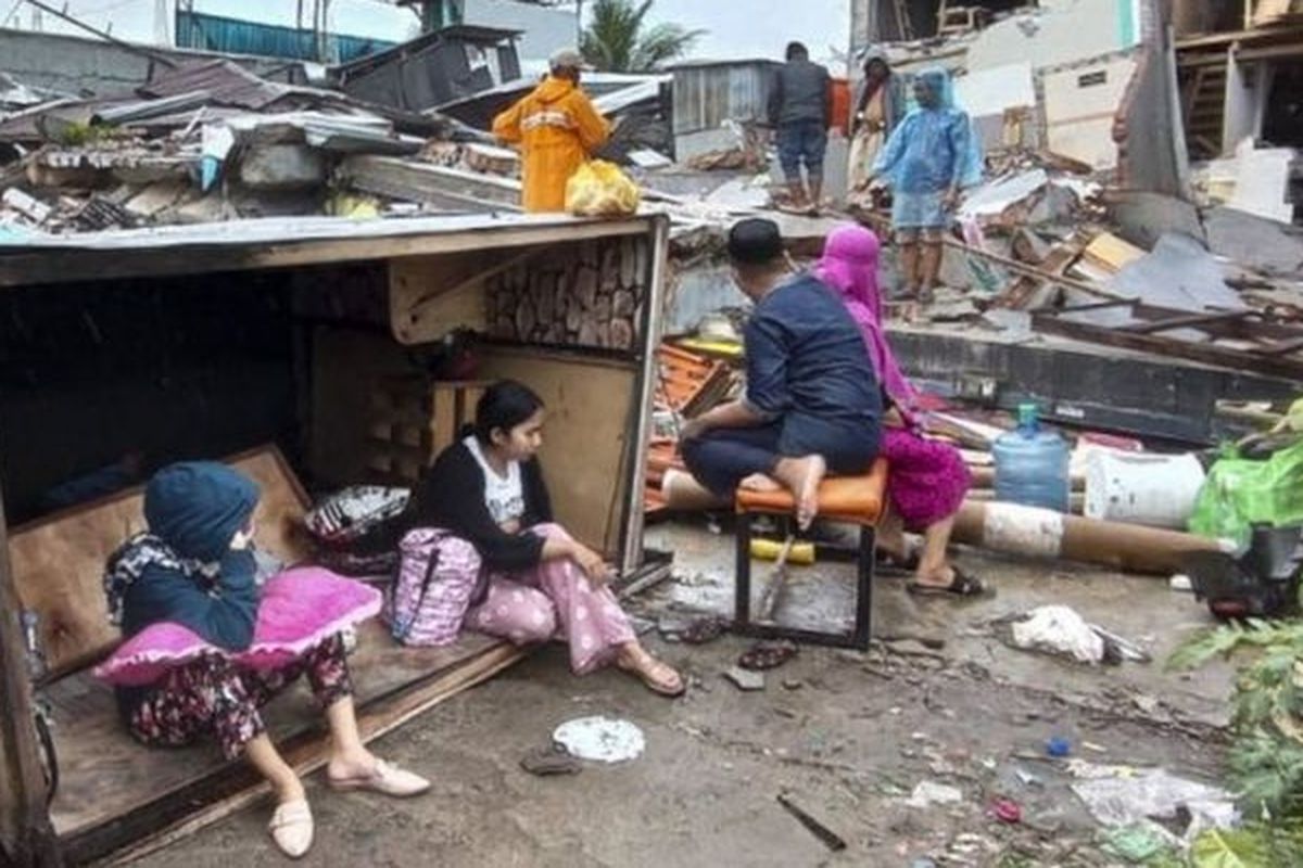 Korban gempa Mamuju berlindung di luar rumah mereka.