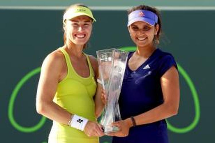 Petenis Swiss, Martina Hingis (kiri), dan petenis India, Sania Mirza, berpose dengan trofi juara di Miami Terbuka setelah memenangi laga final melawan Ekaterina Makarova/Elena Vesnina di Crandon Park Tennis Center, Minggu (5/4/2015).