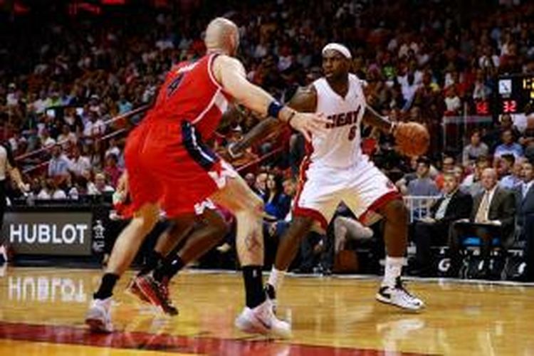 Pebasket Miami Heat, LeBron James (kanana) mencoba melewati pemain Washington Wizards, Marcin Gortat, saat kedua tim bertemu pada laga lanjutan kompetisi NBA, Minggu (3/11/2013) di American Airlines Arena, Miami.