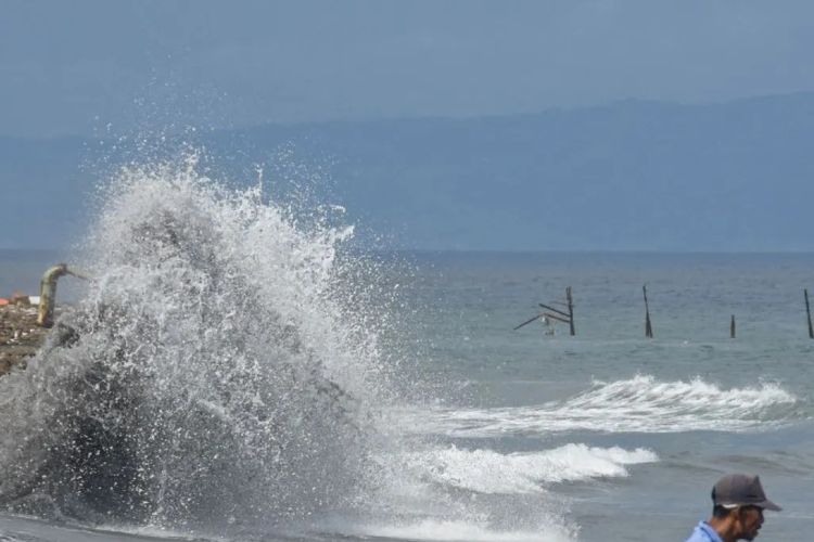 Gambar warga berdiri di pinggiran pantai Ampenan saat terjadi gelombang tinggi di sepanjang pesisir pantai Ampenan, Mataram, NTB. BMKG memperingatkan potensi banjir rob di pesisir NTB 19?26 November 2025 akibat fase bulan baru. Menurut BMKG, hujan intensitas tinggi bakal melanda sejumlah wilayah selama Natal 2025 dan Tahun Baru 2026 (Nataru 2026).