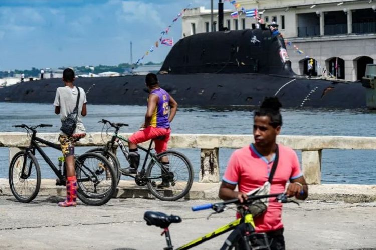 Warga Havana, Kuba, menontong kapal selam bertenaga nuklir Rusia, Kazan, yang merupakan bagian dari konvoi angkatan laut Rusia yang mengunjungi Kuba, setelah tiba di pelabuhan Havana tanggal 12 Juni 2024.