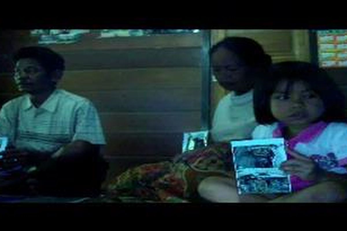 Orang tua dan adik memegang foto Sertu Frans, anggota TNI yang tewas setelah terjadi kontak senjata di puncak jaya papua. 