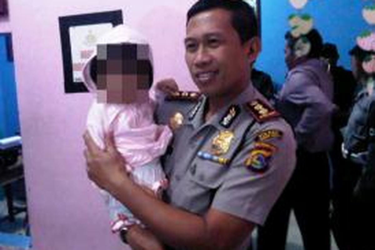 Balita 17 bulan yang diduga sebagai korban penculikan saat digendong Kapolres Lombok Barat AKBP Yulianus Yulianto. 