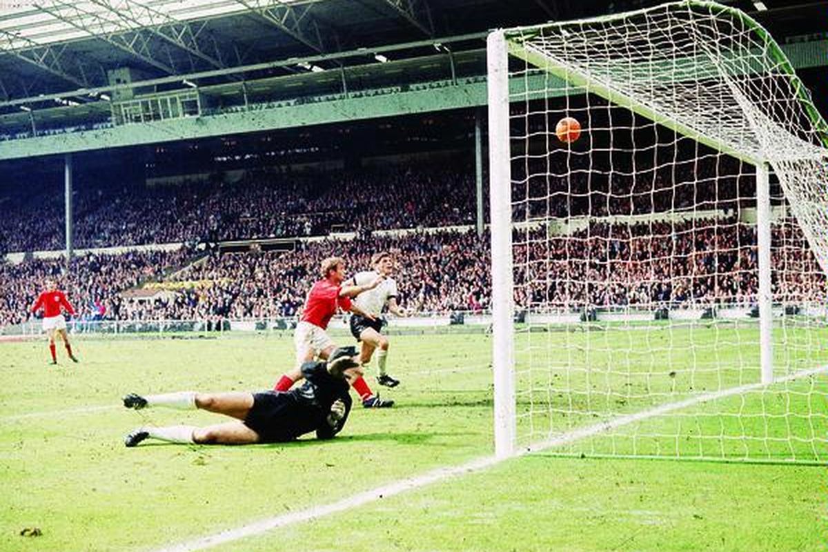 PemainInggris, Geoff Hurst (tengah), mencetak gol ketiga ke gawang Jerman Barat pada laga final Piala Dunia 1966 di Stadion Wembley, London, Inggris. Inggris, negara asal sepak bola modern, sekali- kalinya menjadi juara dunia melalui gol Hurst yang kontroversial.