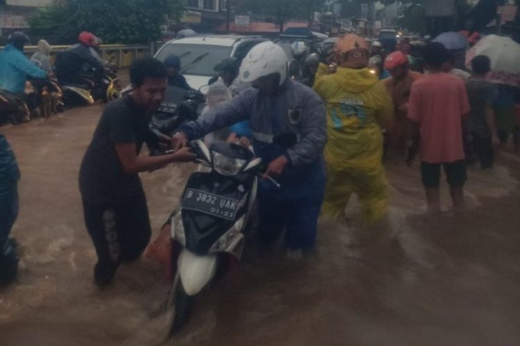 Petugas Suku Dinas Perhubungan Jakarta Timur menolong pengendara motor yang terjebak banjir di Jalan Molek Pondok Gede, Cipayung, Selasa (25/2/2020). 