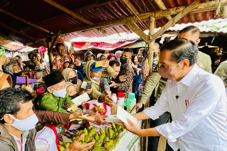 Presiden Joko Widodo menyerahkan bantuan sosial kepada pedagang di Pasar Baros, Serang, Banten, Jumat (17/6/2022).
