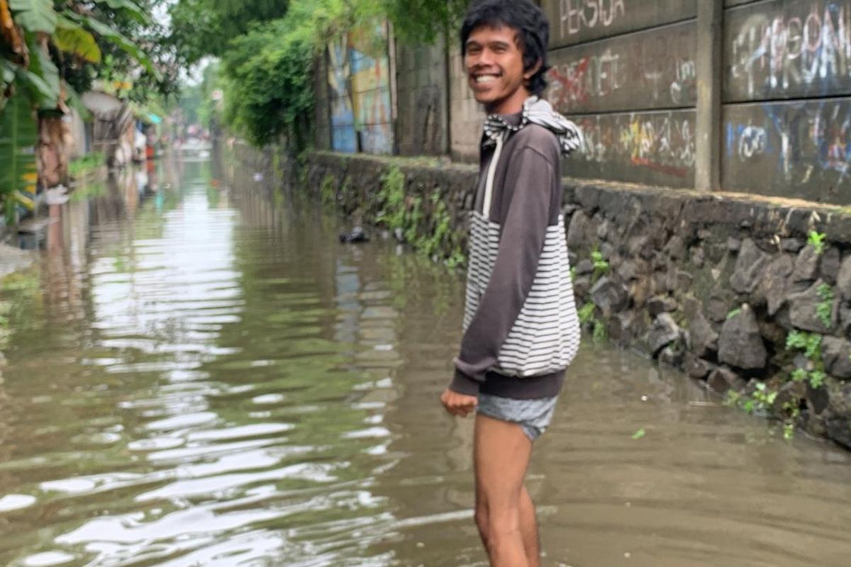 Bayu (32), warga Kampung Sawah, Semper Timur, Cilincing Jakarta Utara, harus menerjang banjir demi nyoblos di TPS 115, Rabu (14/2/2024). 