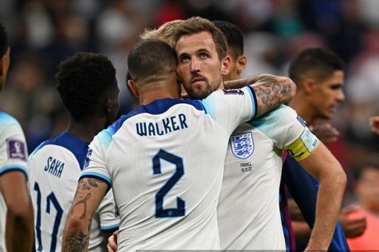 Kyle Walker memeluk Harry Kane seusai Inggris dibekuk Perancis dalam babak perempat final Piala Dunia 2022 di Stadion Al-Bayt pada Minggu (11/12/2022) dini hari WIB.. (Photo by Paul ELLIS / AFP)