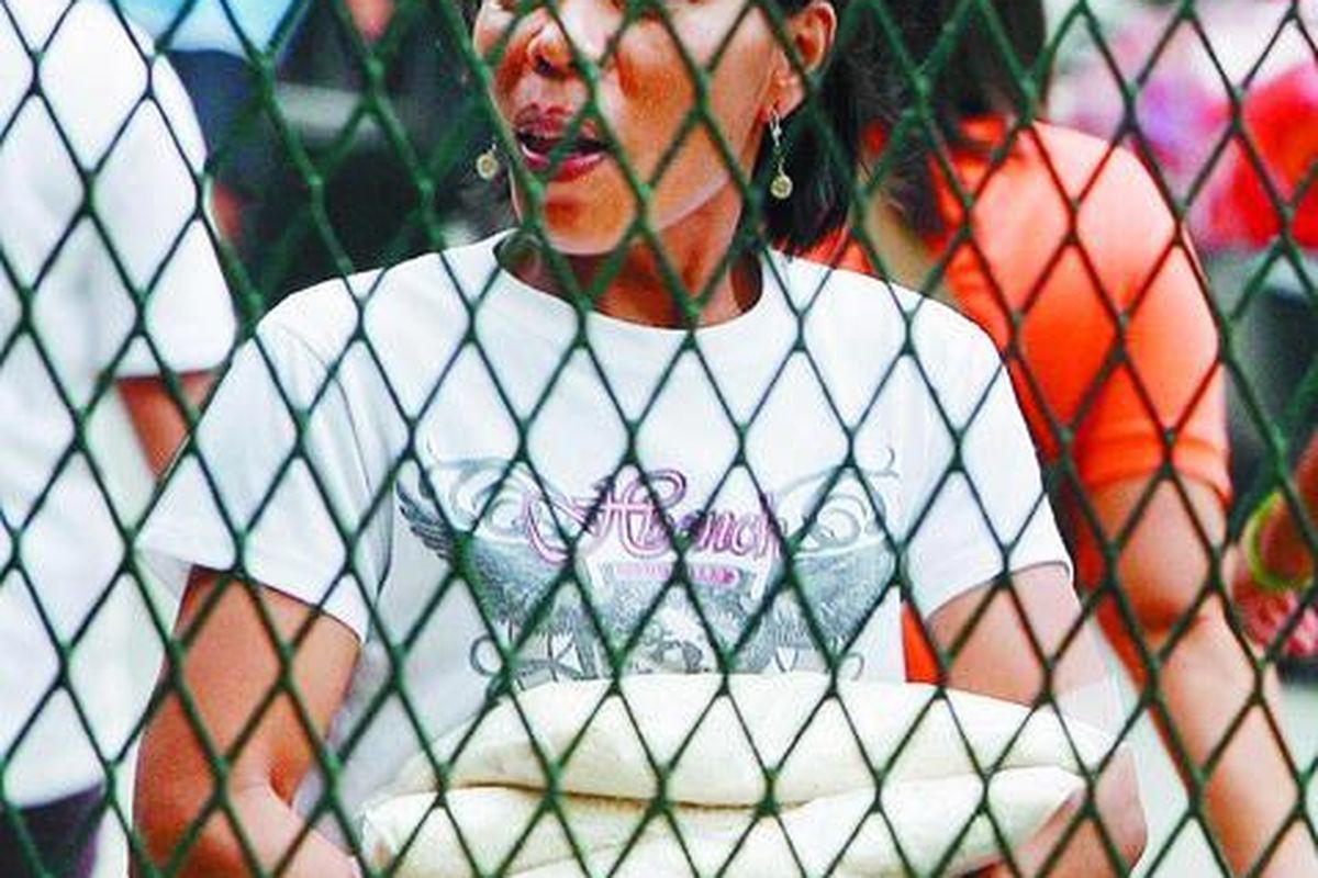 Warga Filipina membawa beberapa bungkus beras yang dibeli dari Otoritas Pangan Nasional (NFA) di Quezon City, Manila timur, Jumat (25/4). Pemerintah telah memulai pembagian beras murah kepada warga miskin.  