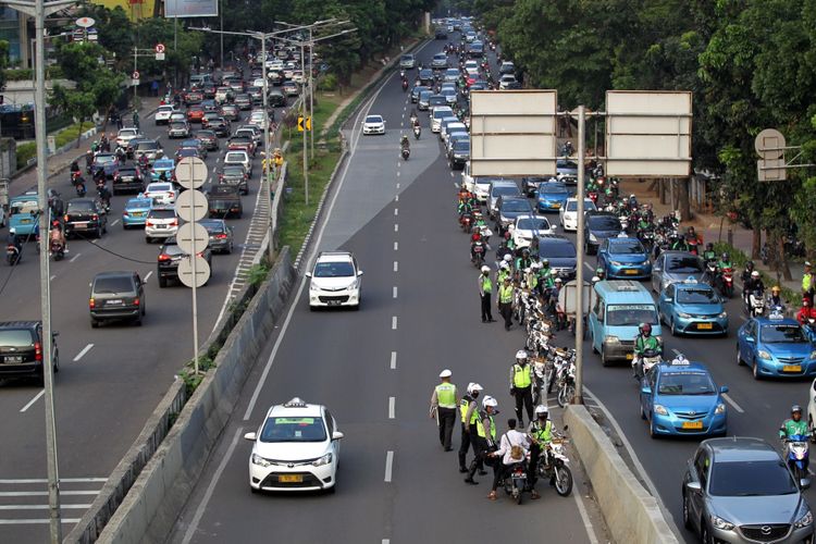 Polisi melakukan razia sepeda motor yang nekat menerobos ke jalan layang non tol (JLNT) Kampung Melayu-Tanah Abang, Jakarta, Selasa (25/7/2017). Pengendara motor masih nekat memasuki dan melintasi JLNT tersebut baik dari arah Tanah Abang maupun Kampung Melayu. KOMPAS IMAGES/KRISTIANTO PURNOMO