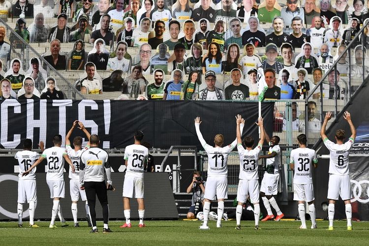 Para pemain Moenchengladbach merayakan di depan kardus dengan foto-foto penggemar Moenchengladbach ditampilkan di tribun, setelah pertandingan sepak bola Bundesliga divisi satu Jerman Borussia Moenchengladbach v Union Berlin di Moenchengladbach, Jerman barat, pada 31 Mei, 2020.