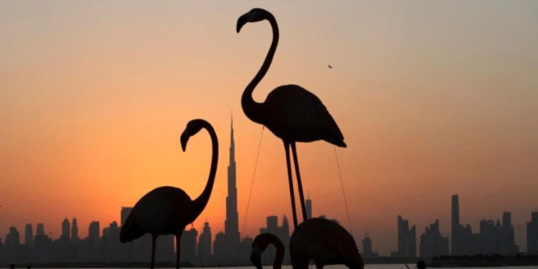Cakrawala kota dengan latar belakang Burj Khalifa, gedung tertinggi di dunia, dibingkai oleh patung flamingo saat matahari terbenam di Dubai, Uni Emirat Arab, Selasa, 15 Oktober 2019.