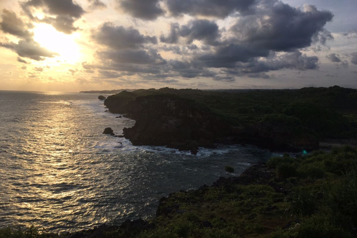 Pemandangan matahari terbenam dari atas bukit di Pantai Krakal