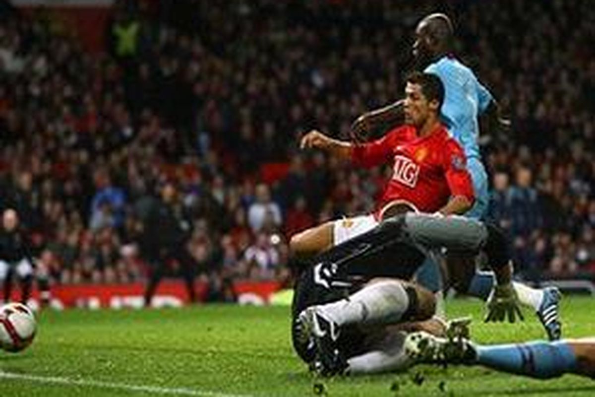 Cristiano Ronaldo mencocor bola saat menyambut umpan Dimitar Berbatov, untuk mencetak gol kedua MU saat taklukkan West Ham United 2-0