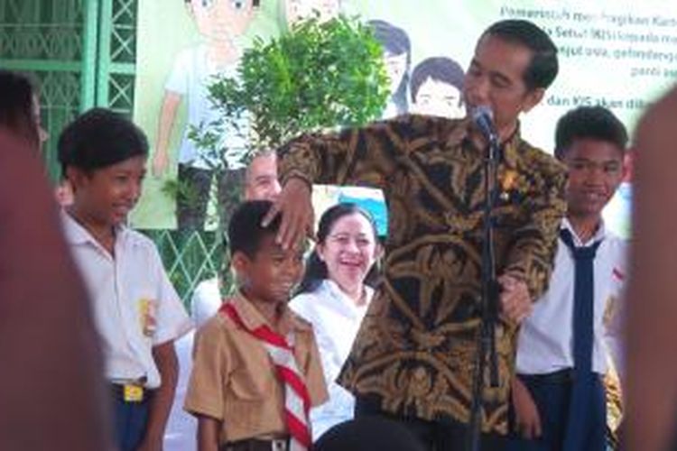 Presiden Joko Widodo bercanda dengan seorang bocah saat membagikan Kartu Indonesia Sehat (KIS), Kartu Indonesia Pintar (KIP), dan Kartu Keluarga Sejahtera (KKS) di Kampung Melayu, Jakarta, Rabu (13/5/2015).