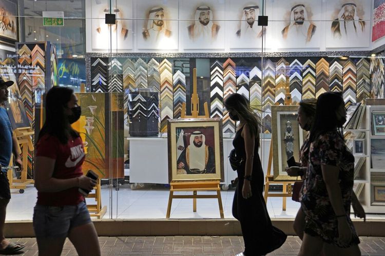 Orang-orang melewati foto Sheikh Khalifa bin Zayed Al Nahyan, di Dubai, Uni Emirat Arab, Jumat, 13 Mei 2022. 