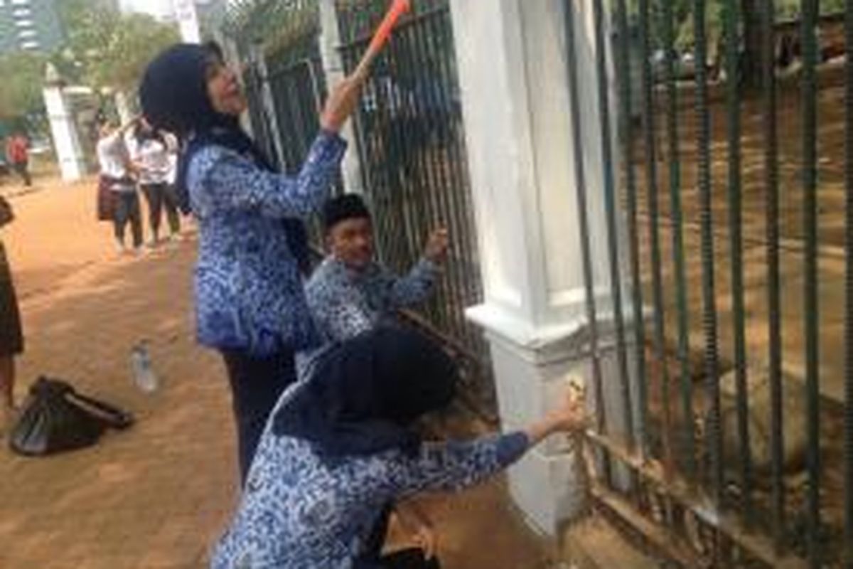 Sejumlah Pegawai Negeri Sipil terlihat sedang mengecat pagar kawasan Monas, Jakarta, Selasa (10/11/2015).