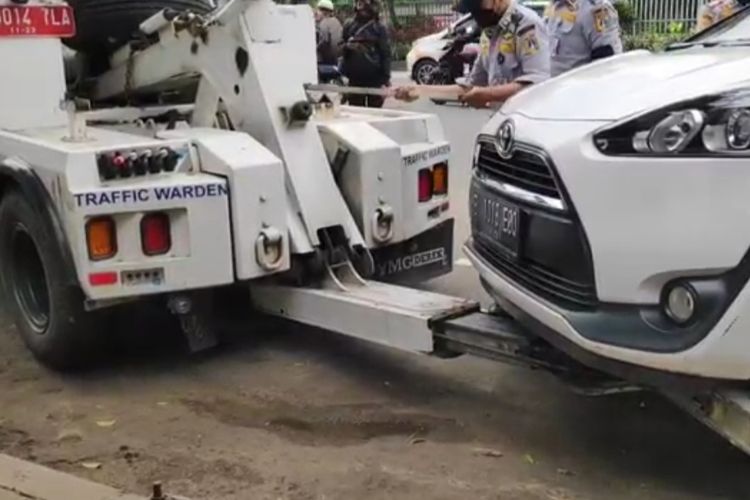Sebanyak tujuh mobil diderek petugas saat penertiban parkir liar di Jalan Matraman Raya, Matraman, Jakarta Timur, Senin (6/12/2021).