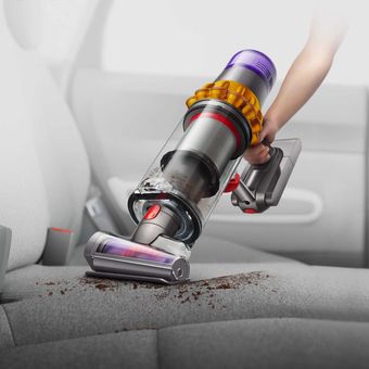 Dyson V15 Detect melakukan penyedotan debu pada permukaan sofa.