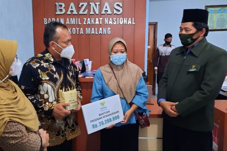 S (40) guru TK yang terjerat Pinjol didampingi kuasa hukumnya saat menerima bantuan Rp 26.200.000 dari Baznas Kota Malang untuk pelunasan hutangnya, Jumat (21/5/2021).