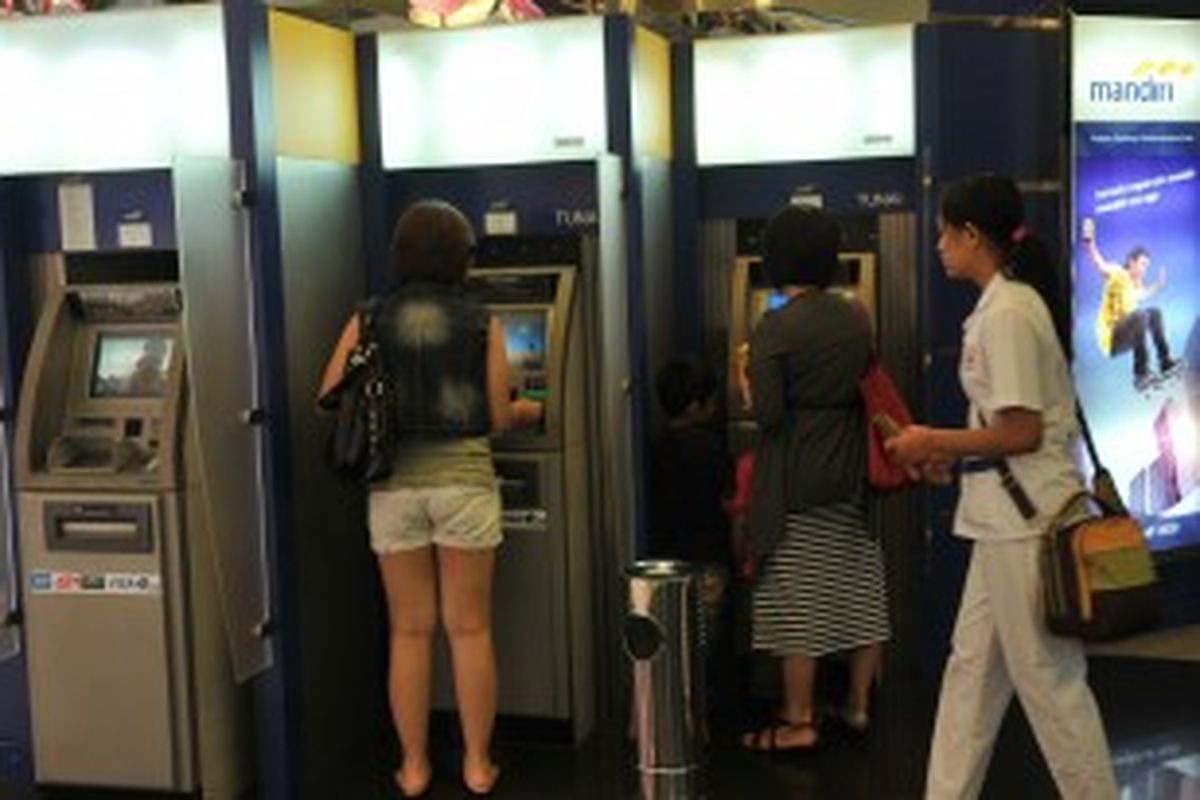 Pengambilan uang tunai di Anjungan Tunai Mandiri (ATM) Bank Mandiri, Jakarta