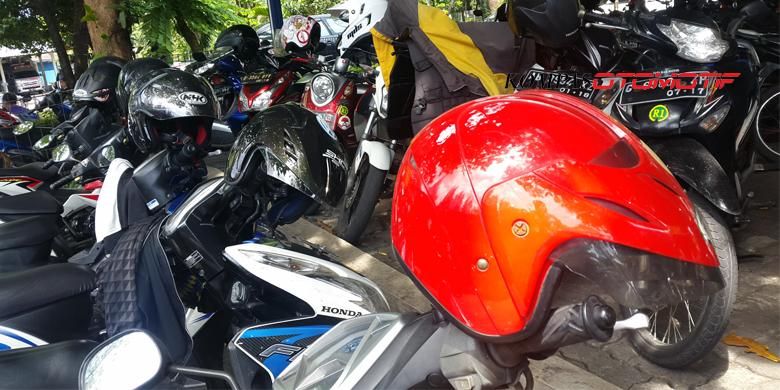 Kebiasaan buruk biker meletakan helm di spion ketika motor parkir. 