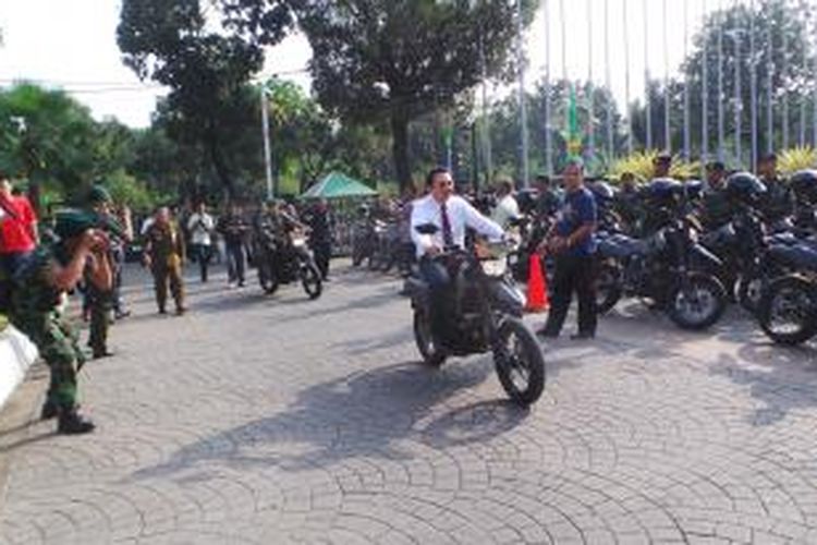 Gubernur DKI Jakarta Basuki Tjahaja Purnama saat mencoba menaiki motor hibah TNI. DKI menyerahkan hibah 326 motor Kawasaki D-Tracker 250 CC serta 2950 set perlengkapan Pasukan Anti Huru Hara kepada personel Kodam Jaya, di Balai Kota, Jumat (7/8/2015). 