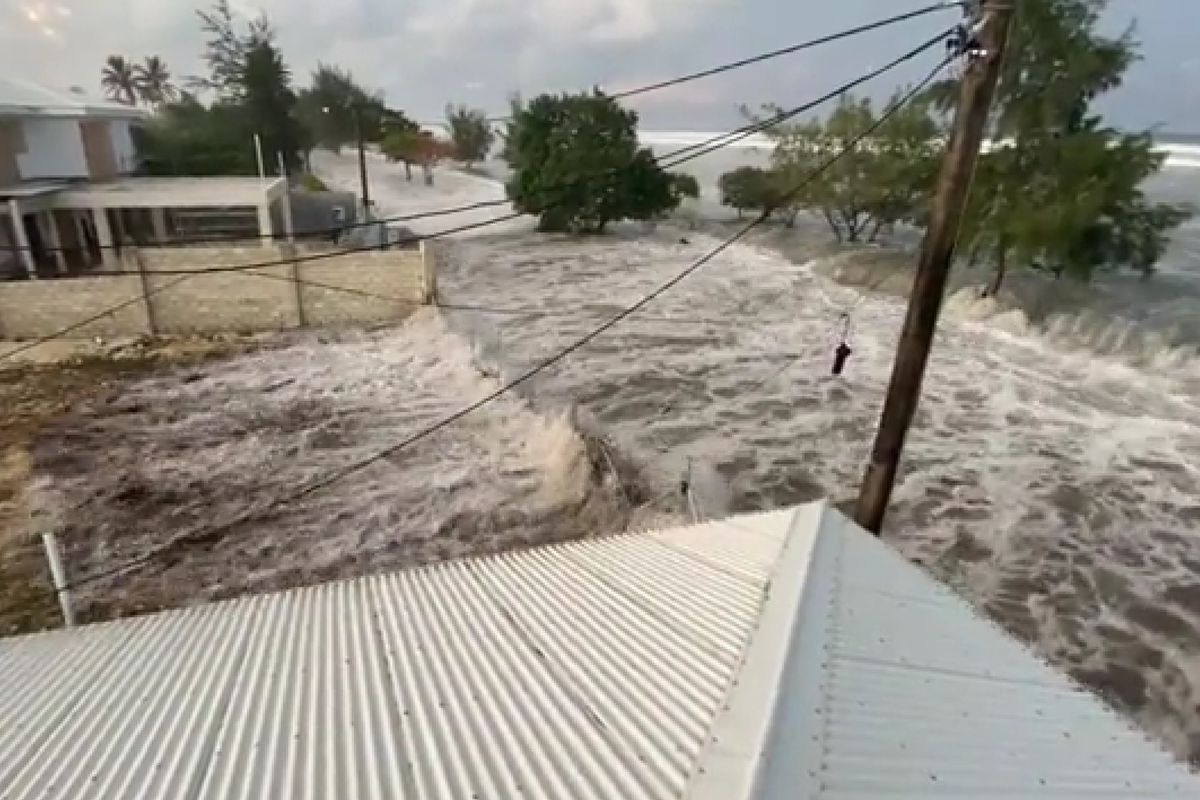 Tangkapan layar dari video yang merekam ombak tinggi menerjang wilayah pesisir dan menerjang beberapa rumah di Tonga. Sebuah gunung berapi bawah laut di Pasifik meletus dan memunculkan peringatan tsunami di beberapa negara, termasuk Tonga dan Selandia Baru pad aSabtu (15/1/2022).