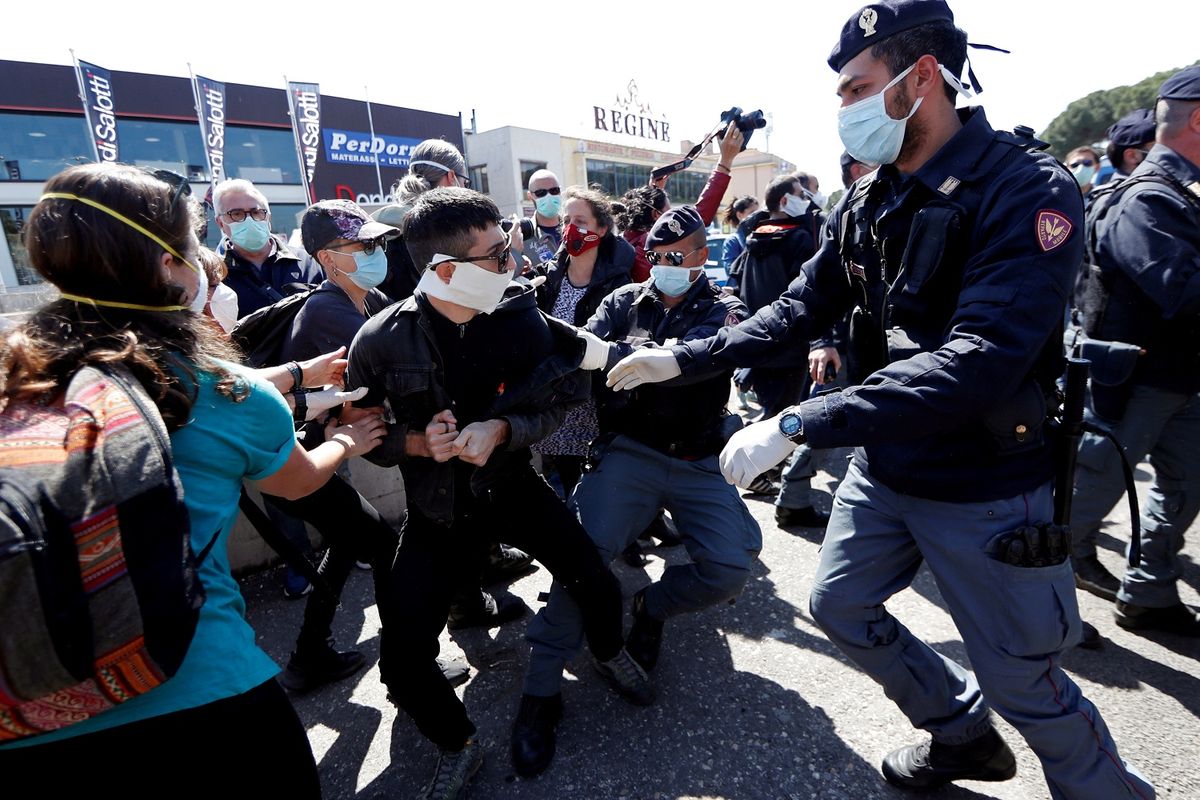 Polisi menahan gerak massa yang berdemonstrasi di luar penjara Rebibbia. Demonstran menuntut lingkungan yang lebih bersih di dalam penjara, di tengah merebaknya pandemi virus corona di Italia. Foto diambil pada 16 April 2020.