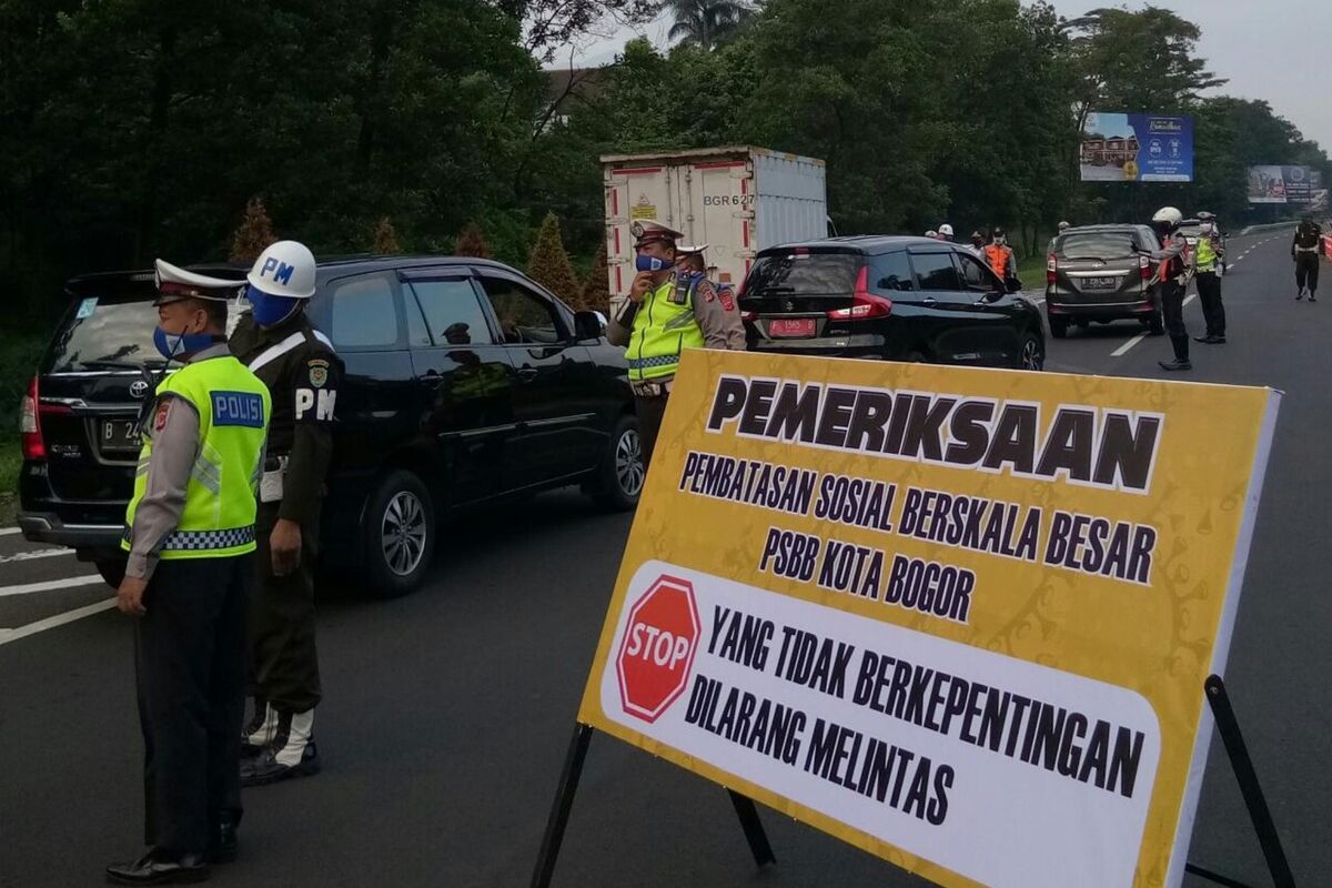 Petugas gabungan sedang melakukan pemeriksaan kendaraan yang melintas di pintu Tol Jagorawi di hari pertama penerapan pembatasan sosial berskala besar (PSBB) Kota Bogor, Rabu (15/4/2020).
