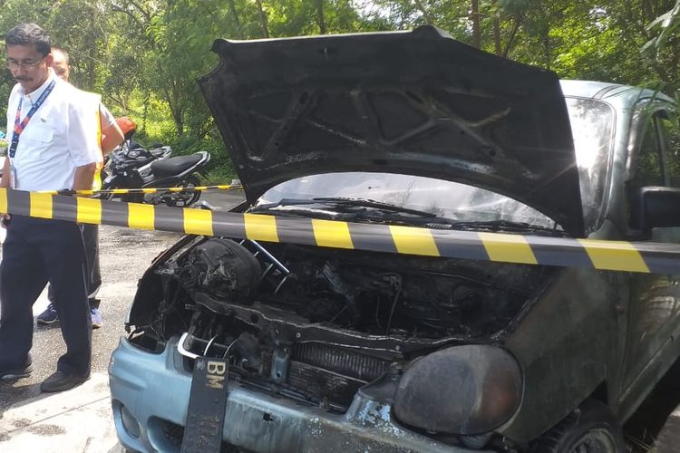 GM Angkas Pura II Jaya Tahoma Sirait dan petugas lainnya melihat kondisi mobil KIA yang terbakar di areal Bandara Internasional SSK II Pekanbaru, Riau, Rabu (26/6/2019). 