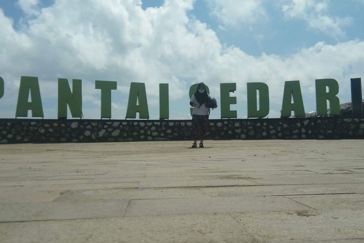 Seorang wisatawan berfoto dengan latar belakang Pantai Sedari, salah satu obyek wisata pantai di Karawang, Jawa Barat.