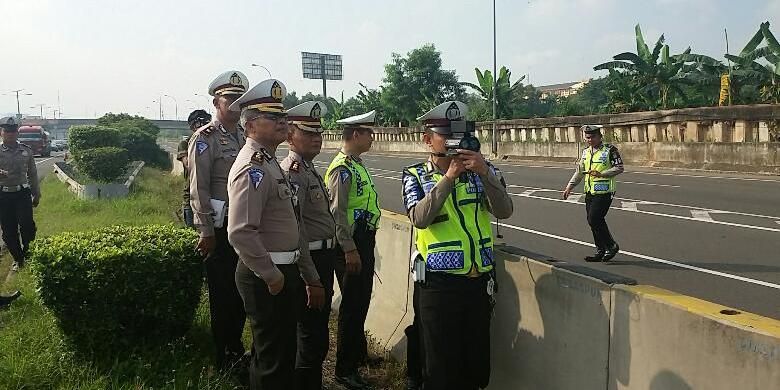 Petugas kepolisian dari Direktorat Lalu Lintas Polda Metro Jaya melakukan uji coba pembatasan kecepatan dengan menggunakan Speed Gun di tol yang mengarah ke bandara pada KM 25-900, Jakarta, Sabtu (12/3/2016).