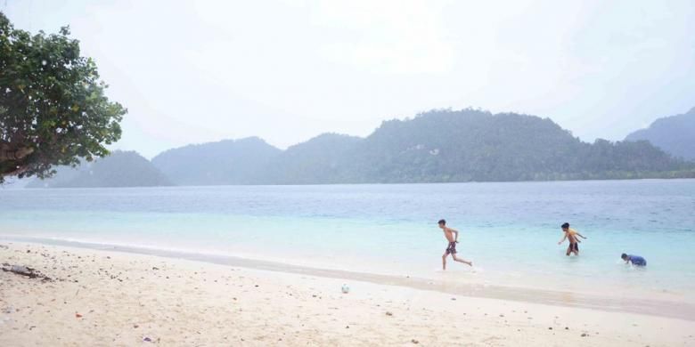 Keceriaan pengunjung saat menikmati keindahan alam dan kejernihan air di Pulau Pagang.