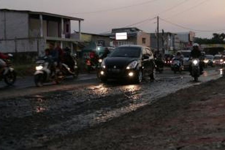 Kondisi fisik infrastruktur jalan di Jl Siliwangi, Kota Tangerang Selatan, Rabu (29/7/2015). Drainase yang buruk dan saluran air yang tersumbat menyebabkan ruas jalan ini selalu rusak meskipun sudah diperbaiki berkali-kali.