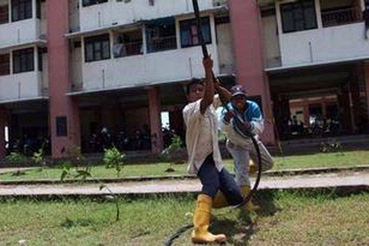 Pekerja memasang kabel di tiang listrik yang terdapat diantara bangunan Rumah susun marunda, Jakarta Utara, Minggu (3/2/2013). Pemasang ini dilakukan untuk memenuhi kebutuhan listrik di semua tower rusun yang akan digunakan warga.  