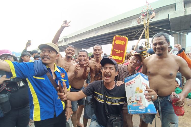 Salah satu tim yang mewakili RW 10 dalam lomba panjat pinang berhadiah emas di Kalimalang, Cipinang Melayu, Makasar, Jakarta Timur, Minggu (20/8/2023). Mereka berhasil menjadi tim pertama yang meraih emas.