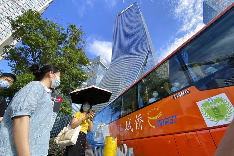 Dalam foto arsip 24 September 2021 ini, warga melintas di depan markas Evergrande, pusat, di Shenzhen, China, yang sahamnya telah ditangguhkan dari perdagangan di Hong Kong, Senin, 4 Oktober 2021. 