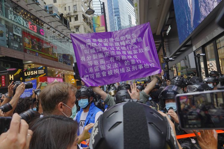 Polisi memajang spanduk pengumuman publik yang menunjukkan peringatan kepada pengunjuk rasa di Causeway Bay sebelum pawai serah terima tahunan di Hong Kong, Rabu (1/7/2020). Hong Kong menandai peringatan 23 tahun penyerahannya ke Cina pada tahun 1997, dan hanya satu hari setelah Cina memberlakukan undang-undang keamanan nasional yang menindak protes di wilayah tersebut.