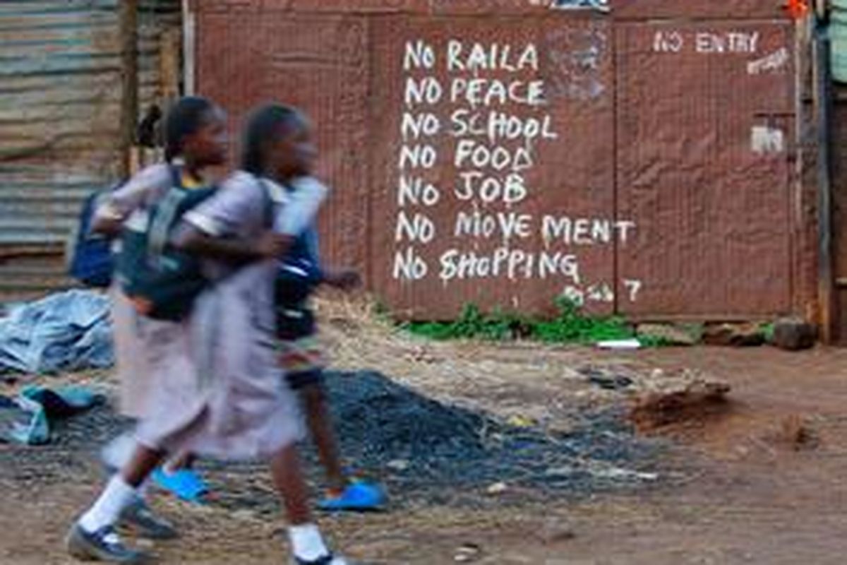 Dua siswi di Eldoret berjalan di depan tulisan tuntutan perdamaian usai kerusuhan Kenya. Banyak gadis putus sekolah kemudian terjerumus ke prostitusi.  