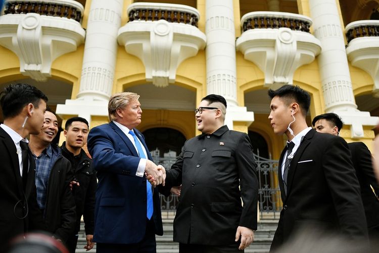 Peniru Donald Trump, Russell White (kiri) berjabat tangan dengan peniru Kim Jong Un, Howard X, di depan Opera House di Hanoi, Vietnam, Jumat (22/2/2019).