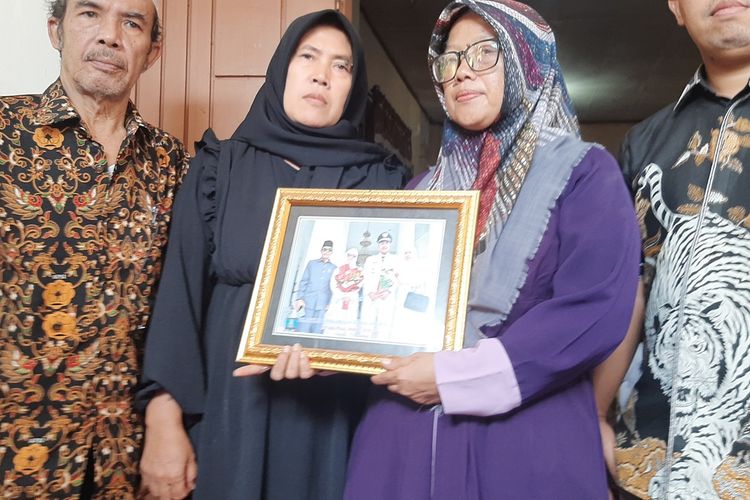 Kuasa hukum korban Eki Wijaya (kanan) bersama istri Kades Curuggoong Salamunasir (kanan kedua) memperlihatkan foto saat pelantikan menjadi Kades.