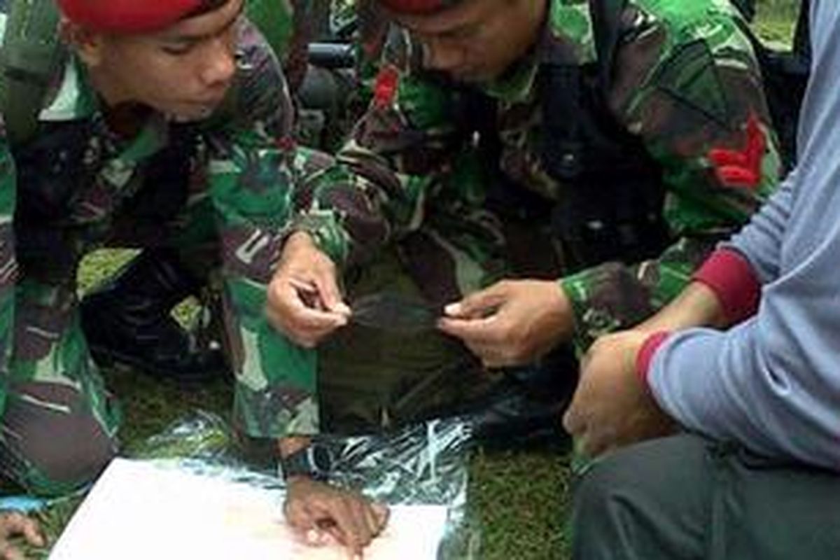 Dua prajurit Kopasus mempelajari medan pencarian dan evakuasi melalui peta kontur di Desa Gunung Sari, Pemijahan, Bogor, Jawa Barat, Kamis (10/5/2012).