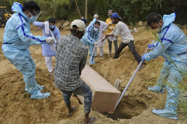 Kerabat menguburkan tubuh korban Covid-19 di kuburan di New Delhi, India, Selasa (4/5/2021).