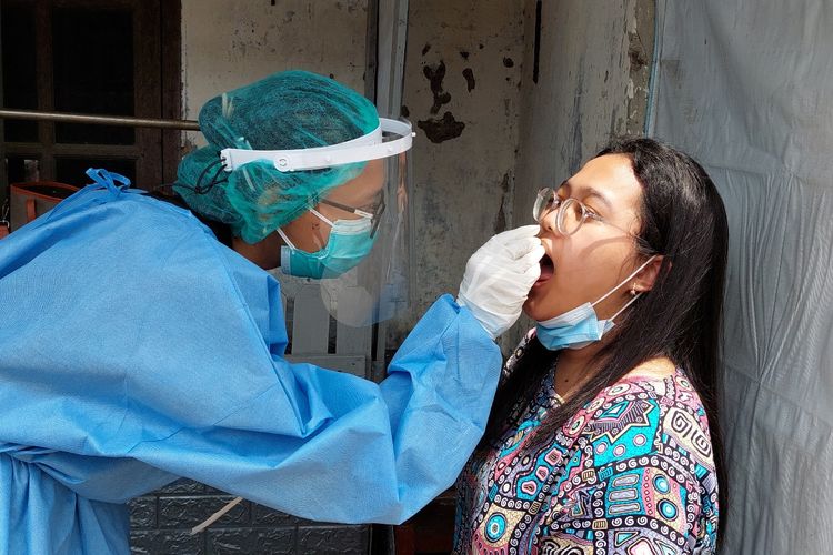 Wahyu (28), seorang dokter dari Puskesmas Kecamatan Tamansari melakukan pemeriksaan warga di wilayah karantina mikro di RW 02, Kelurahan Krukut, Kecamatan Tamansari, Jakarta Barat, Jumat (14/1/2022).