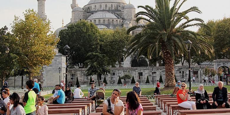 Turis menikmati matahari sore di lapangan di depan Masjid Sultanahmet atau Masjid Biru, Istanbul, Turki, Rabu (7/9/2016).